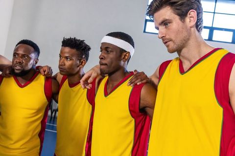 Diverse Basketball Team Embracing Team Spirit on Court