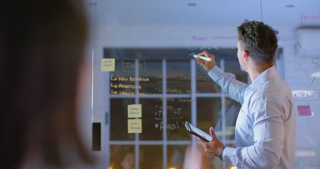 Businessman Strategizing in Modern Office Meeting with Transparent Board - Download Free Stock Images Pikwizard.com