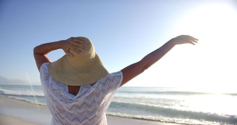 Serene beach moment with sun hat and ocean waves