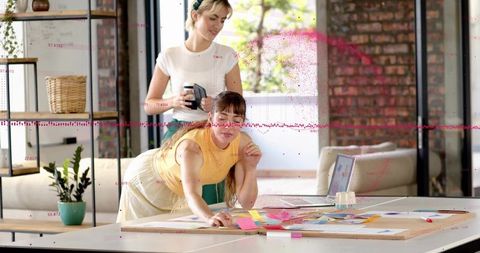 Creative team arranging colorful sticky notes during collaborative planning session