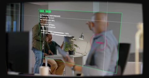 Team collaborating over laptop with executive dashboard hud in modern office