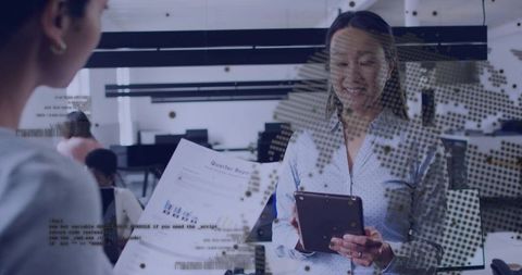 Korean businesswoman reviewing quarter report on tablet with dotted world data overlay