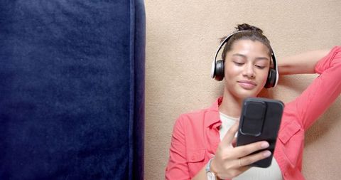 Teenage girl relaxing with headphones and smartphone