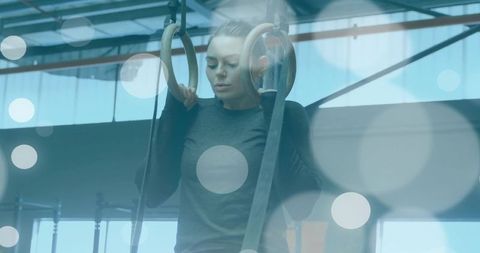 Woman Exercising on Wooden Rings in Industrial Gym Space
