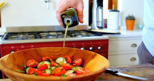 Man Pouring Olive Oil on Fresh Vegetable Salad in Kitchen - Download Free Stock Images Pikwizard.com