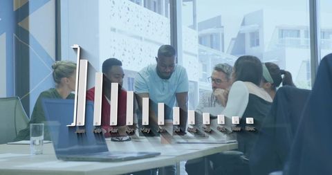 Diverse team collaborating around 3d monthly bar chart during strategy meeting in office