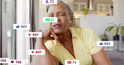 Senior woman leaning and relaxing with earbuds while receiving social media alerts