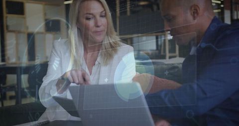 Professionals Viewing Laptop with Digital Interface in Office Lounge