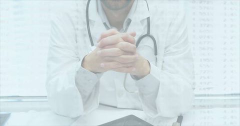 Doctor in Consultation Room Using Digital Tablet with Stethoscope Closeup