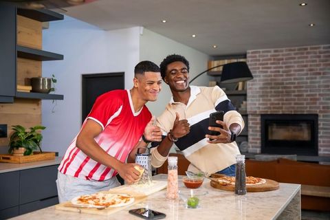 Friends Making Pizza Together in Modern Kitchen