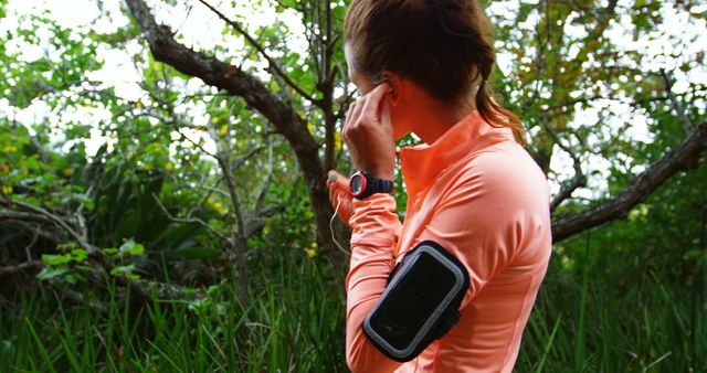 Woman using earphones in the countryside