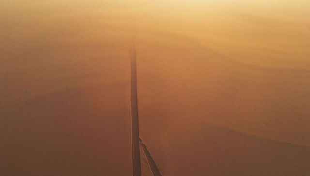 Lonely Road Traversing Vast Golden Desert Landscape
