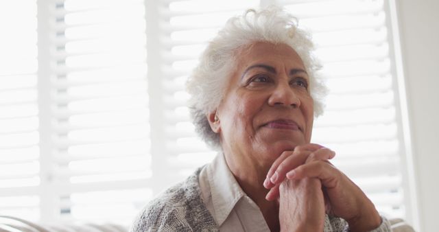 Close up of african american senior woman with hand on chin smiling at home - Download Free Stock Photos Pikwizard.com