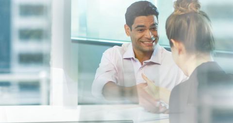 Business Partners Shaking Hands in Modern Office Through Glass