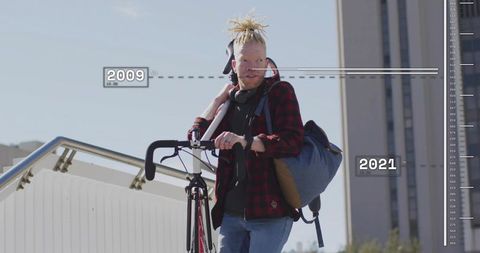 Cyclist carrying bike up urban stairs showing timeline overlay 2009–2021