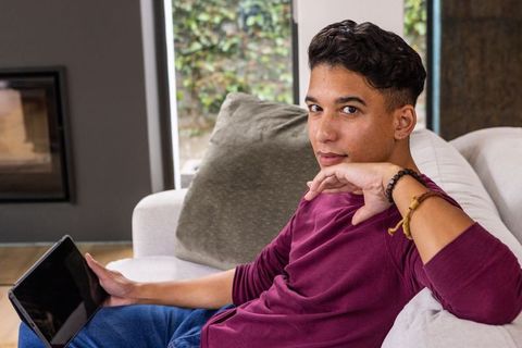 Man relaxing with tablet on modern sofa in stylish living room