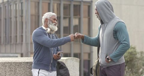 Mature African American Friends Fist-Bumping After Outdoor Workout on Urban Campus Plaza