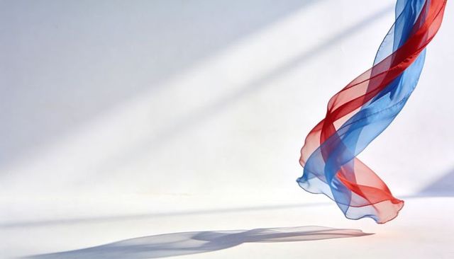Translucent red and blue chiffon ribbon floating and twisting over white background