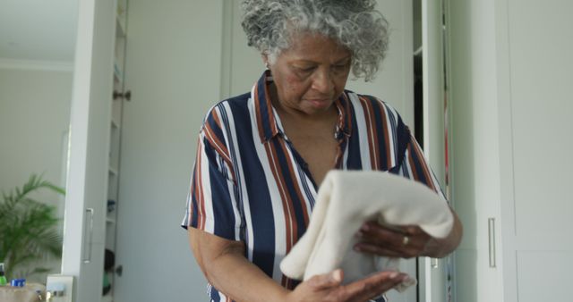 African american senior woman packing suitcase for travel. travel preparation during covid 19 pandemic.