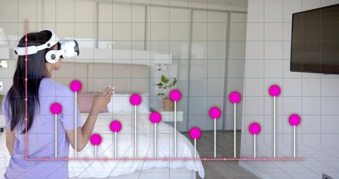Woman using vr headset interacting with augmented data graph overlay in modern bedroom