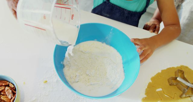 Child Baking Together with Adult, Pouring Milk into Mixing Bowl - Download Free Stock Images Pikwizard.com