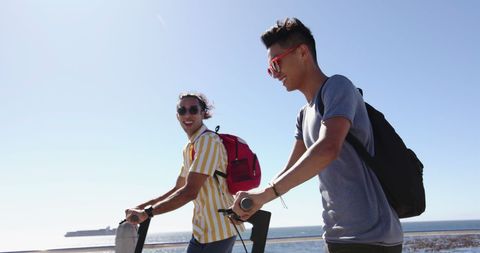 Happy Couple Riding Scooters by the Sea on Sunny Day