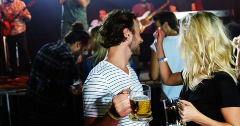 Young Adults Socializing at Lively Party with Drinks