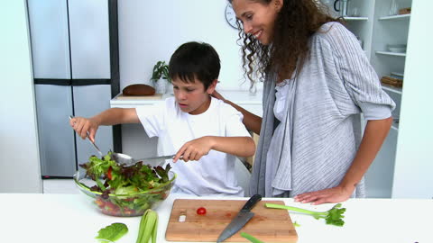 Mother and Son Cooking Salad in Bright Kitchen