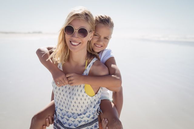 Mother and daughter enjoying quality time together at the beach. Ideal for promoting family vacations, summer activities, and outdoor fun. Great for use in advertising, lifestyle blogs, and travel brochures.