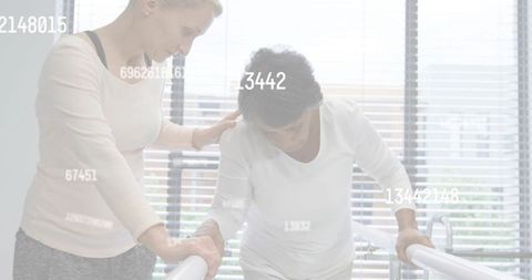 Walking patient receiving caregiver support on parallel bars during gait rehabilitation session