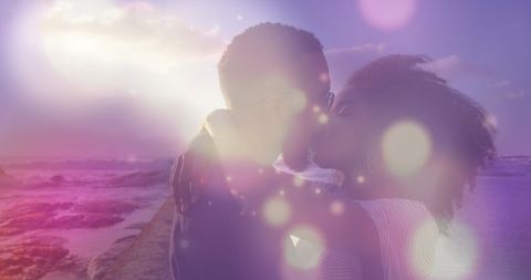 Romantic Couple Kissing on Beach with Dreamy Light Flares