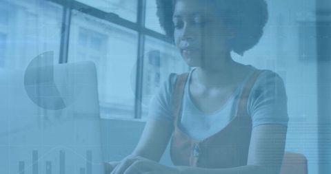 Working woman using laptop analyzing data dashboard in modern urban office by window