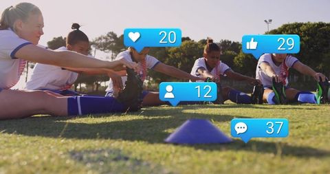 Female youth soccer players stretching on sunny pitch with social media icons overlay