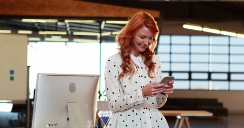 businesswoman messaging on phone in open office - Download Free Stock Images Pikwizard.com