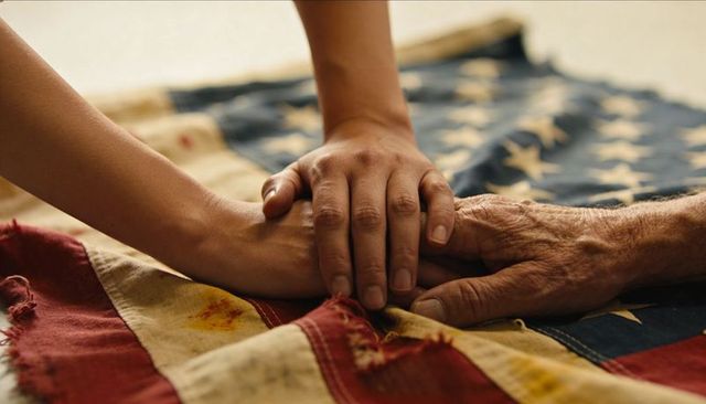 Holding hands over worn american flag showing care, generational bond, compassion, remembrance