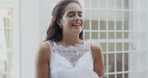 Joyful Bride in Elegant White Dress Smiling Indoors
