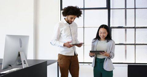 Colleagues Collaborating in Modern Office Using Tablets