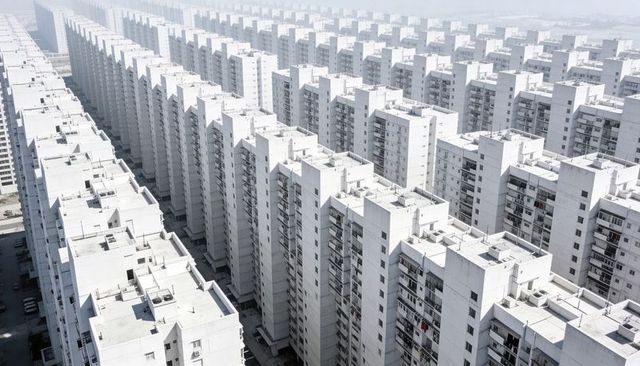 Endless white high-rise grid receding into haze conveying urban density monochrome patterns