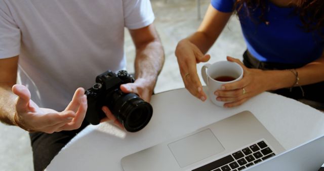 People Discussing Photography Over Coffee and Laptop - Download Free Stock Images Pikwizard.com