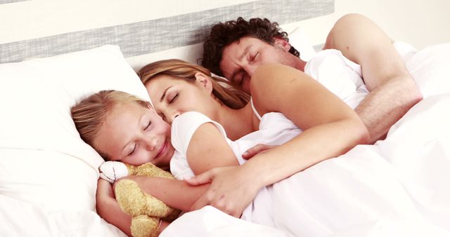 Happy family sleeping together in bed