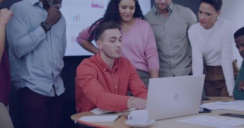 Diverse Team Collaborating Around Laptop Presenting Data and Planning Strategy in Office