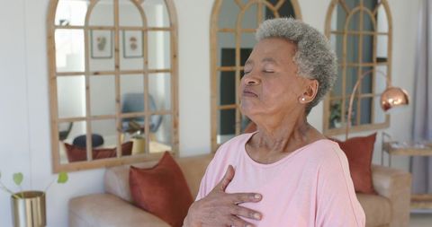 Senior african american woman practicing mindful breathing at home for relaxation and calm