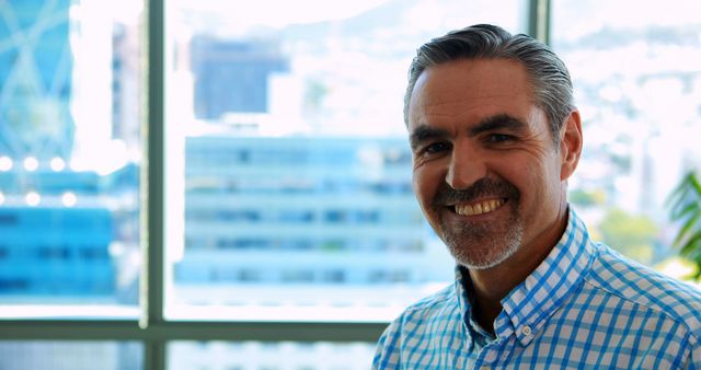 Smiling Middle-Aged Man in Office with City View Background - Download Free Stock Images Pikwizard.com