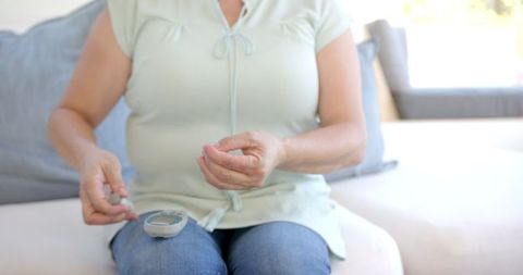 Senior Woman Checking Blood Sugar Levels with Glucometer