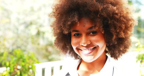 Portrait of smiling waitress with afro hairstyle in restaurant setting