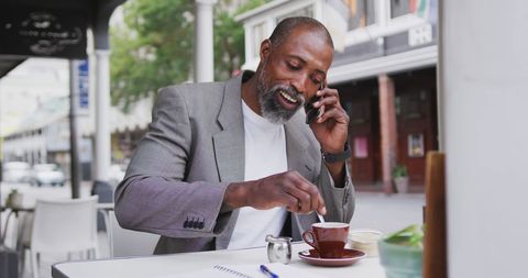 Mature Man in Cafe Enjoying Coffee and Phone Call Outdoors