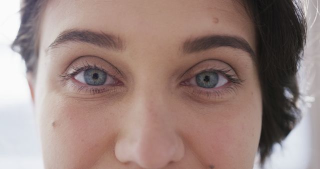Captivating close-up of person showcasing beautiful blue eyes and well-defined facial features. Ideal for use in articles about eye health, beauty tutorials, human emotions, marketing materials for cosmetics, or visual assets for personal blog posts exploring human traits and expressions.