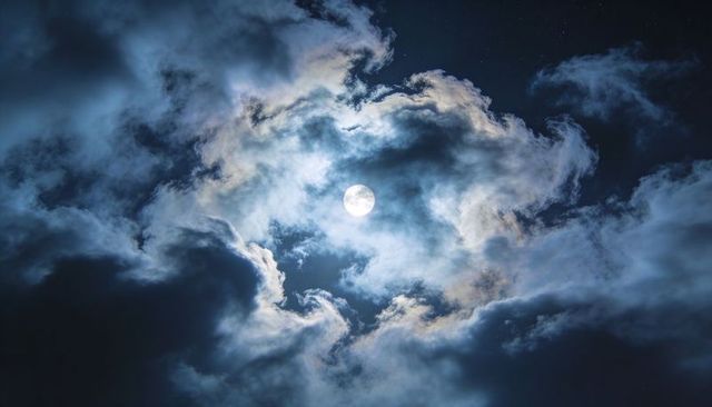 Framing Full Moon with Swirling Cloud Halo over Deep Blue Starry Night Sky