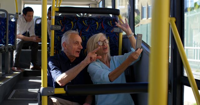 Senior caucasian couple sitting in city bus using smartphone. Communication, transport, city living and senior lifestyle, unaltered.