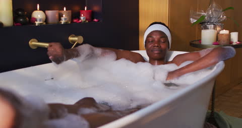 Woman Relaxing in a Luxurious Bubble Bath with Candles